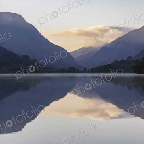 Llyn Padarm, Llanberis, a view across the flat calm waters of the lake with…