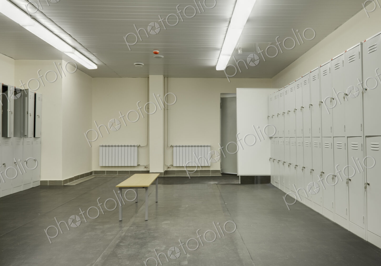 Locker room with rubber mats on floor.