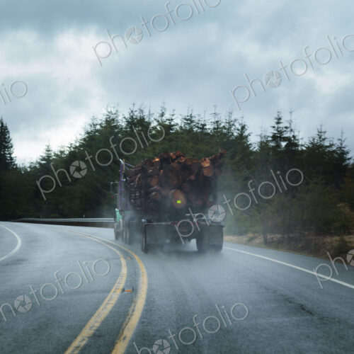 Logging truck in rain on rural highway, Port Angeles, WA, USA