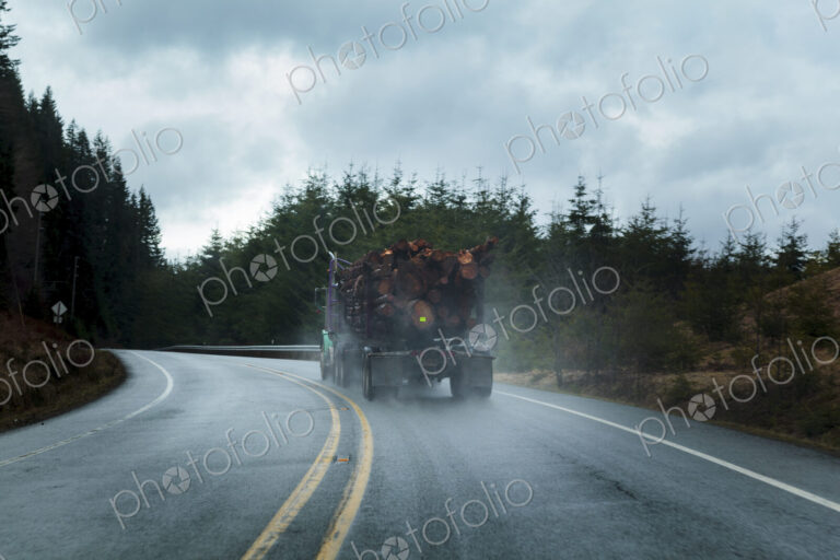 Logging truck in rain on rural highway, Port Angeles, WA, USA