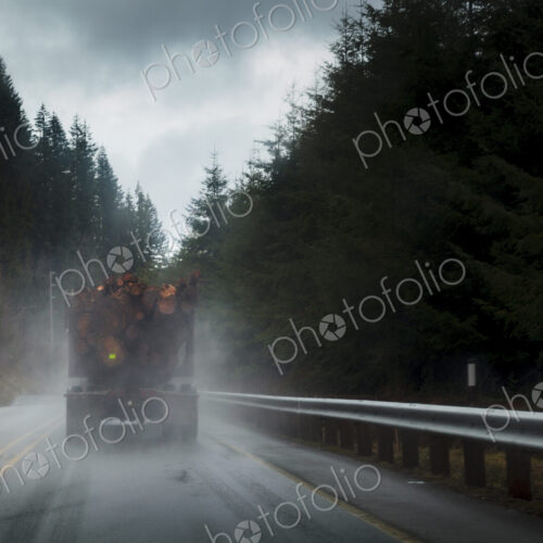 Logging truck in rain on rural highway, Port Angeles, WA, USA