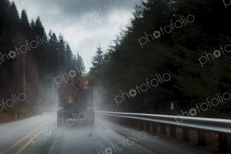 Logging truck in rain on rural highway, Port Angeles, WA, USA