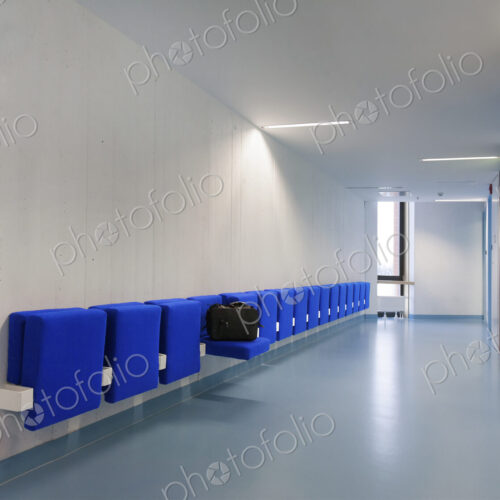 Long corridor in modern training college with blue flip up seats.