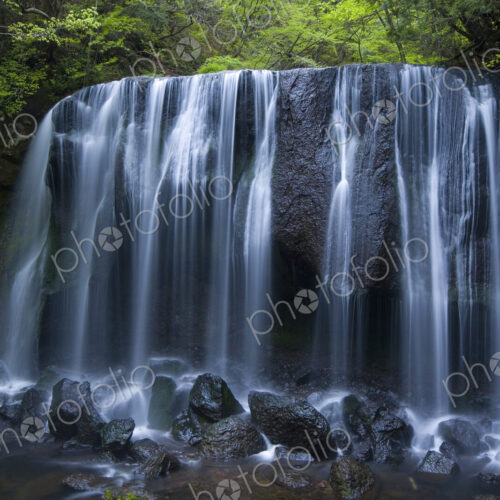 Long exposure of rocky waterfall in forest.