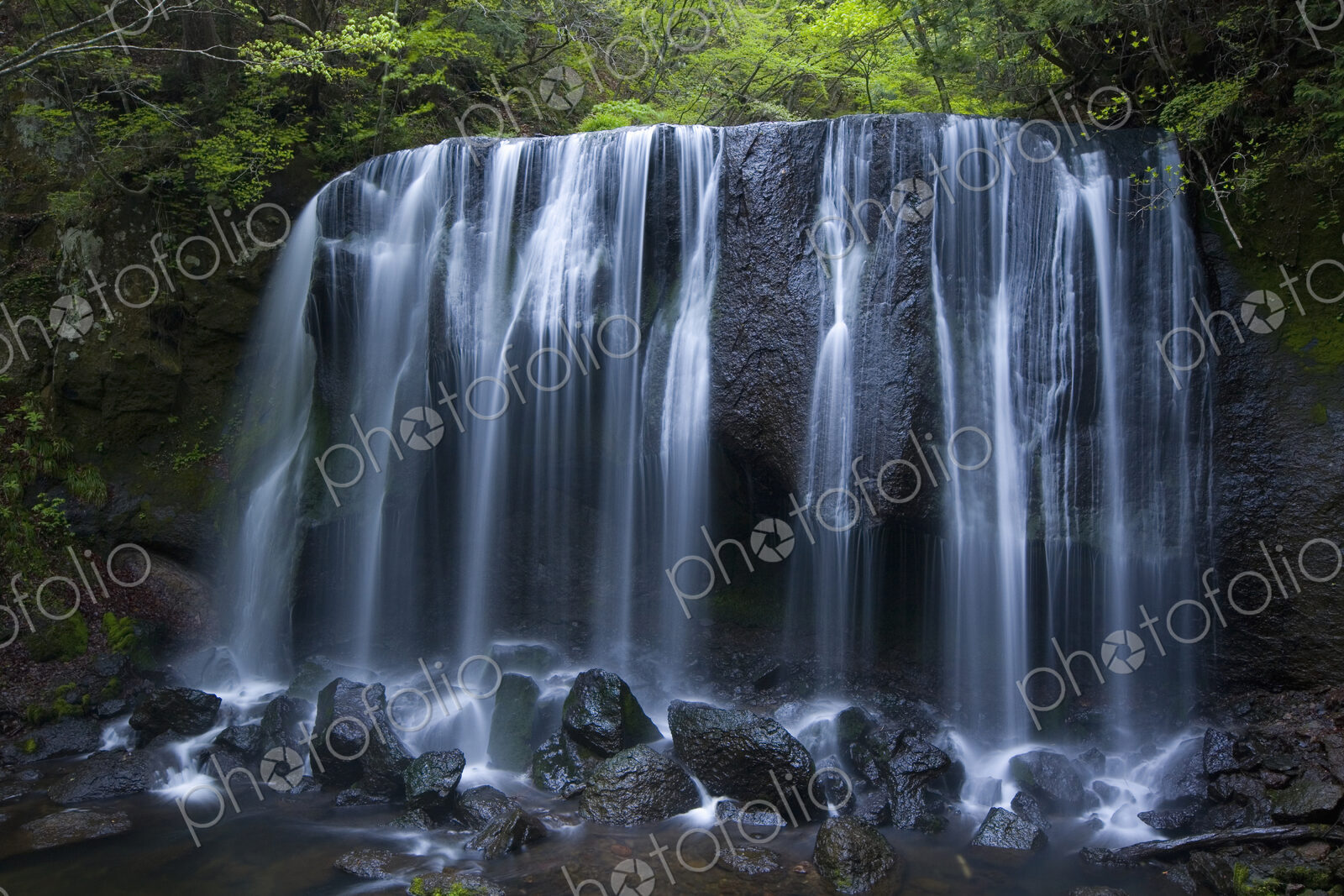 Long exposure of rocky waterfall in forest.
