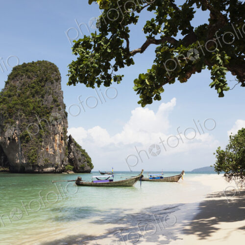 Long tail traditional boats beached and moored on Tham Phra Nang beach. Long tail traditional boats beached and moored on Tham Phra Nang beach.