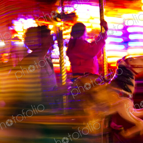 Loof Carrousel at an amusement park in Spokane, blurred motion, people riding gallopers. Loof Carrousel at an amusement park in Spokane, blurred motion, people riding gallopers.