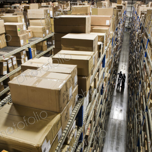 Looking down and over racks of products stored in boxes in a distribution warehouse. Looking down and over racks of products stored in boxes in a distribution warehouse.