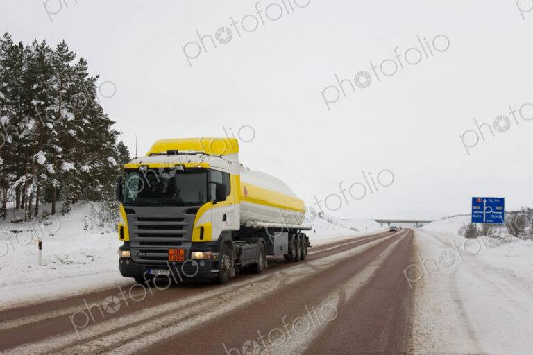 Lorry driving on snowy rural road.