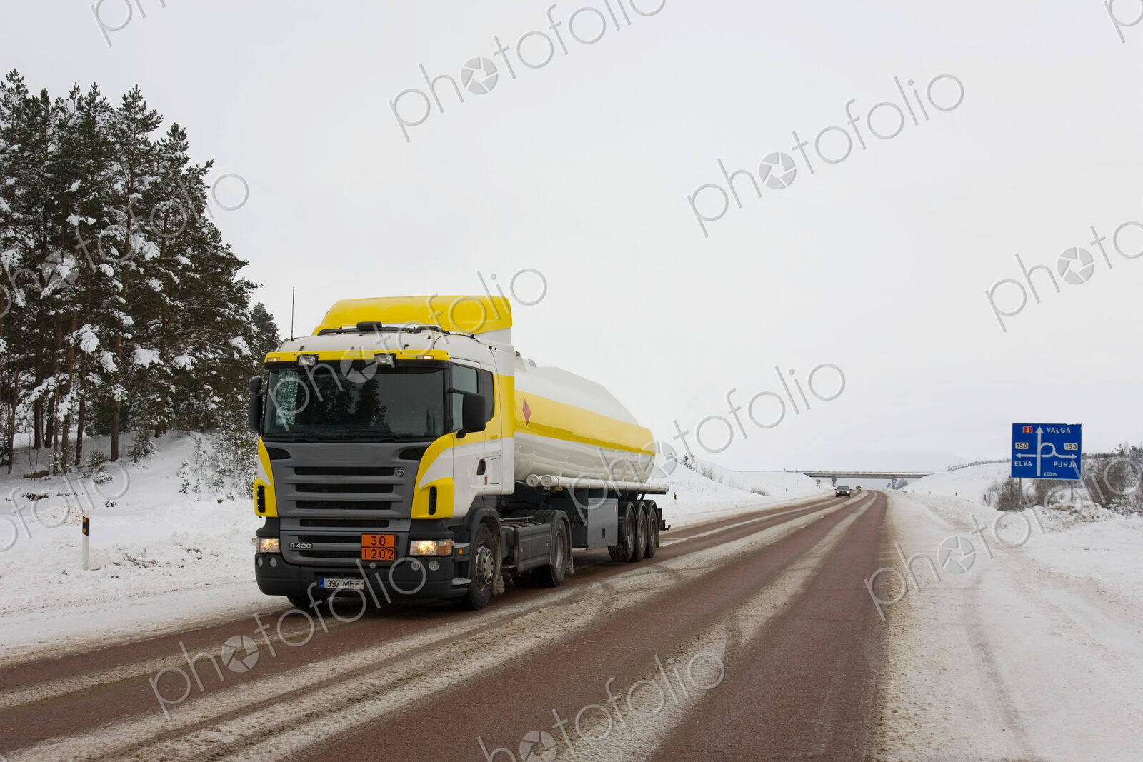 Lorry driving on snowy rural road.