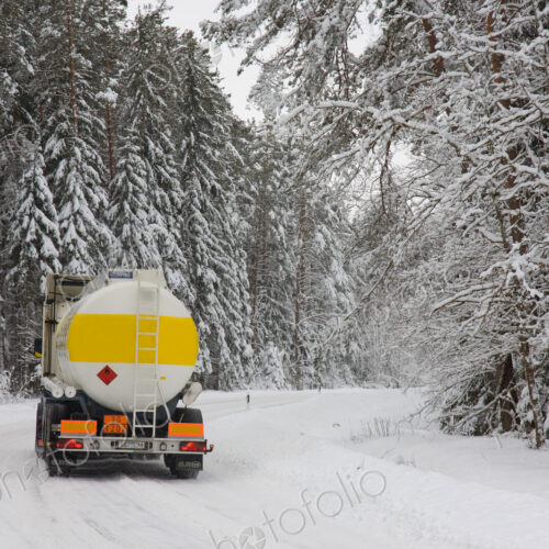 Lorry driving on snowy rural road through forest. Lorry driving on snowy rural road through forest.