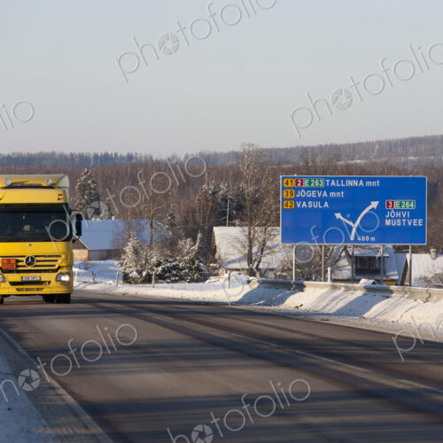 Lorry driving on snowy rural road woith road sign. Lorry driving on snowy rural road woith road sign.