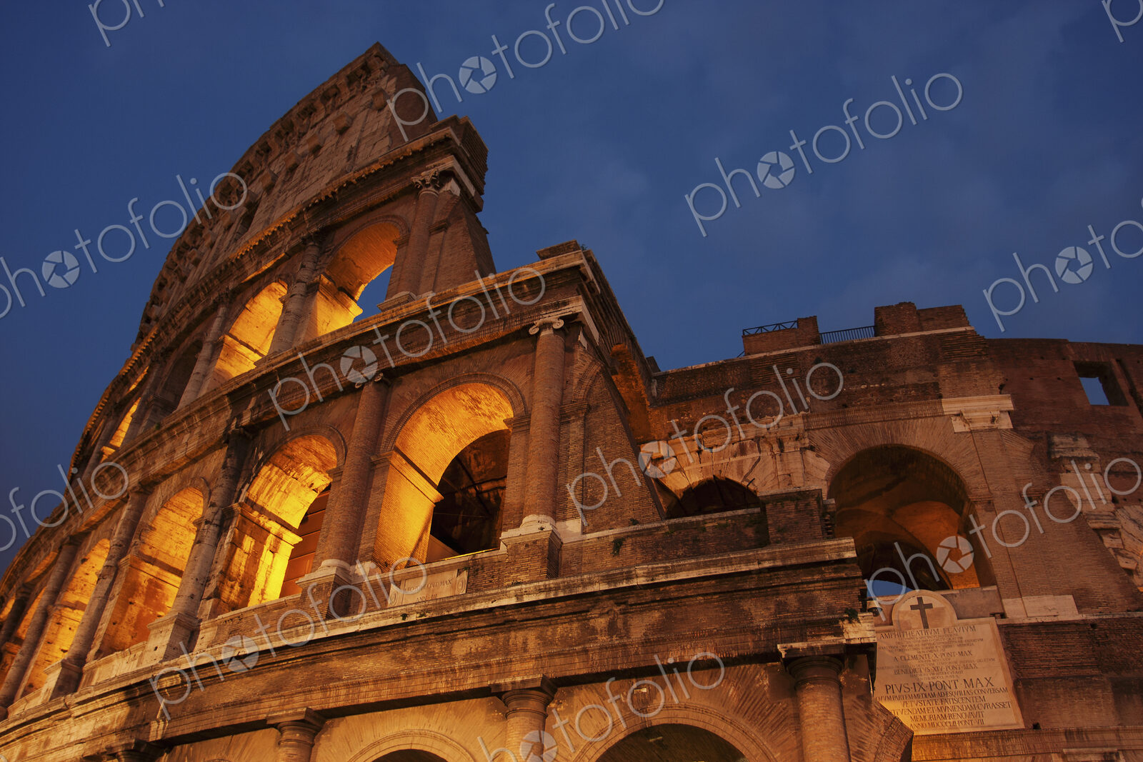 Low angel view of the Colosseum in Rome at dusk.