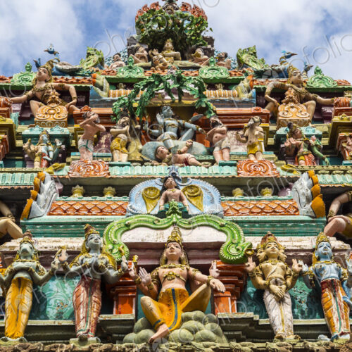 Low angle exterior view of facade of Hindu Temple decorated with colourful sculptures.