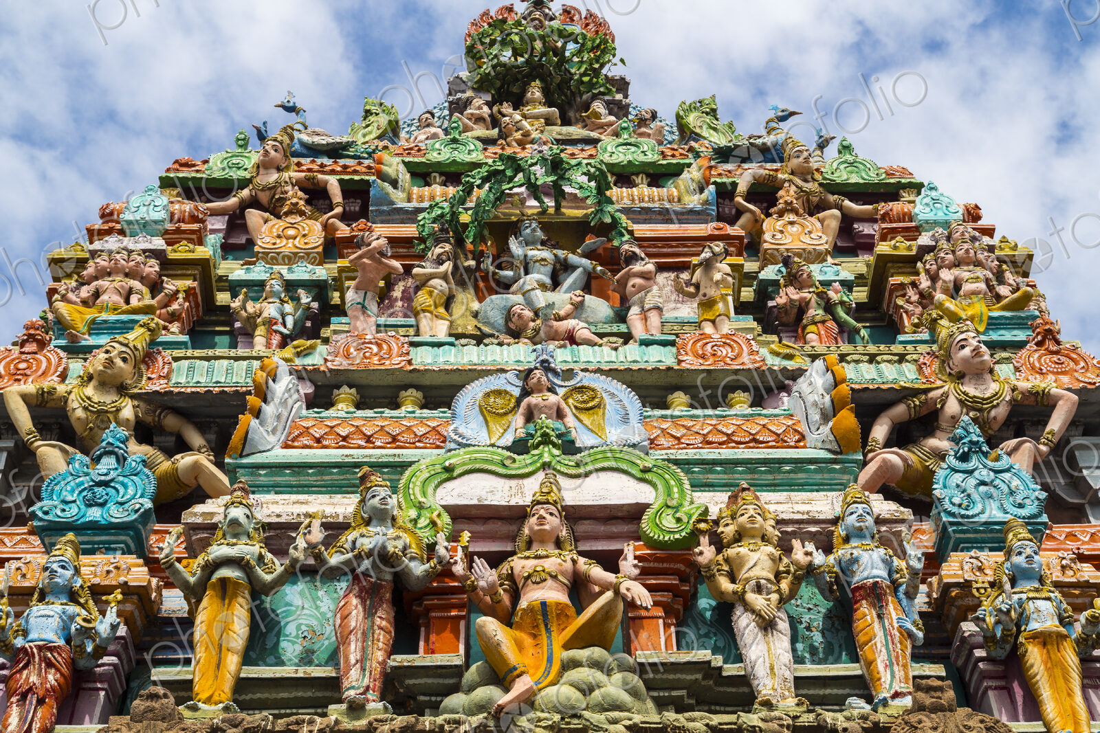 Low angle exterior view of facade of Hindu Temple decorated with colourful sculptures.