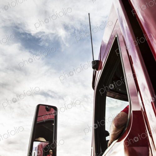 Low angle looking up view of the driver's side window and mirror on a commercial truck. Low angle looking up view of the driver's side window and mirror on a commercial truck.