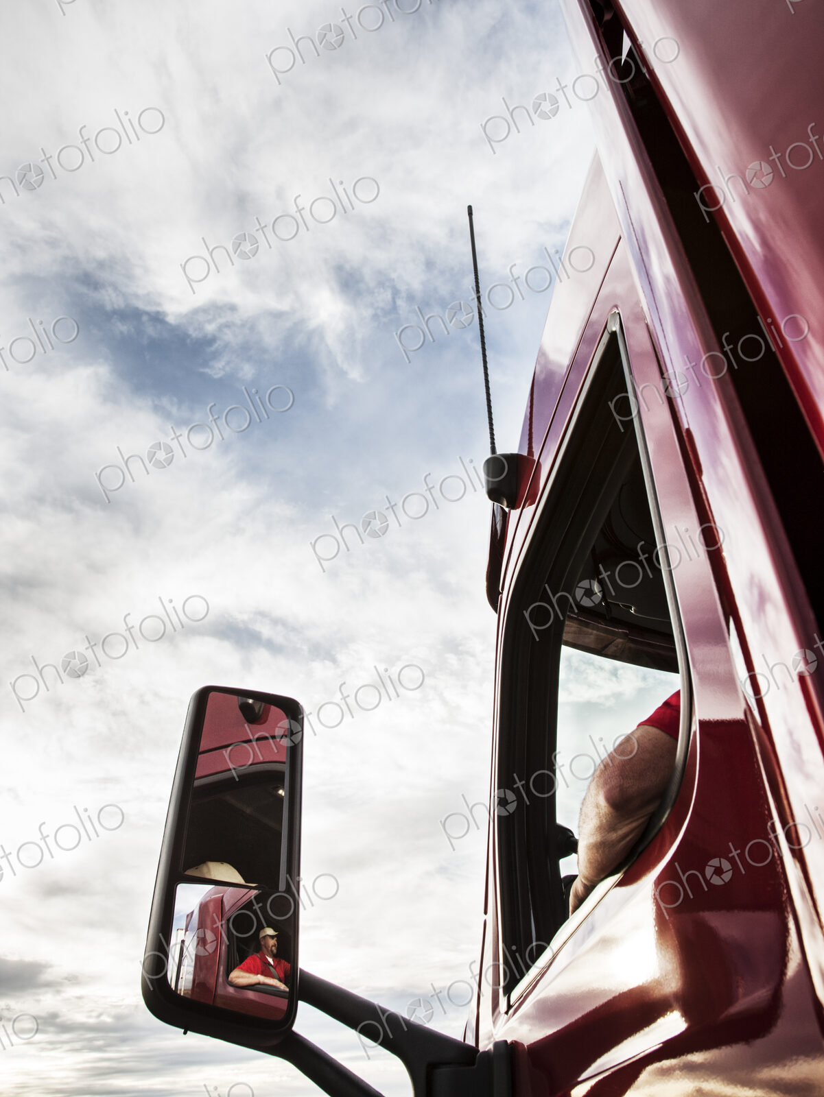 Low angle looking up view of the driver’s side window and mirror on a commercial truck.