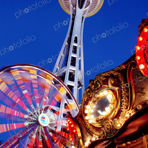 Low angle view of Space Needle, ferris wheel and carousel under night sky Low angle view of Space Needle, ferris wheel and carousel under night sky