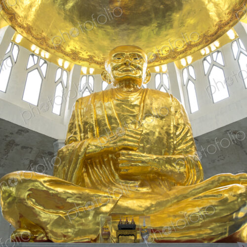 Low angle view of golden Buddha statue in temple, Sikhiu, Nakhon Ratchasima, Thailand Low angle view of golden Buddha statue in temple, Sikhiu, Nakhon Ratchasima, Thailand
