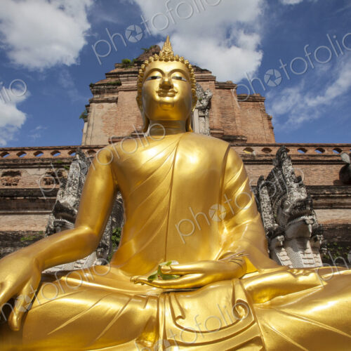 Low angle view of golden Buddha statue outside temple, Chiang Mai, Chiang Mai, Thailand