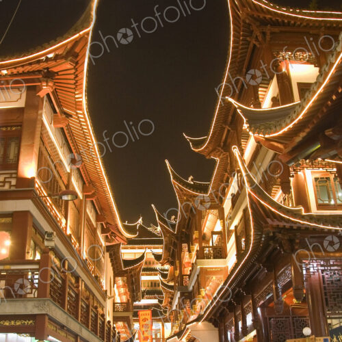 Low angle view of illuminated traditional oriental buildings with balconies at night. Low angle view of illuminated traditional oriental buildings with balconies at night.
