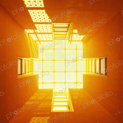 Low angle view of orange light in a lightwell of a building. Low angle view of orange light in a lightwell of a building.