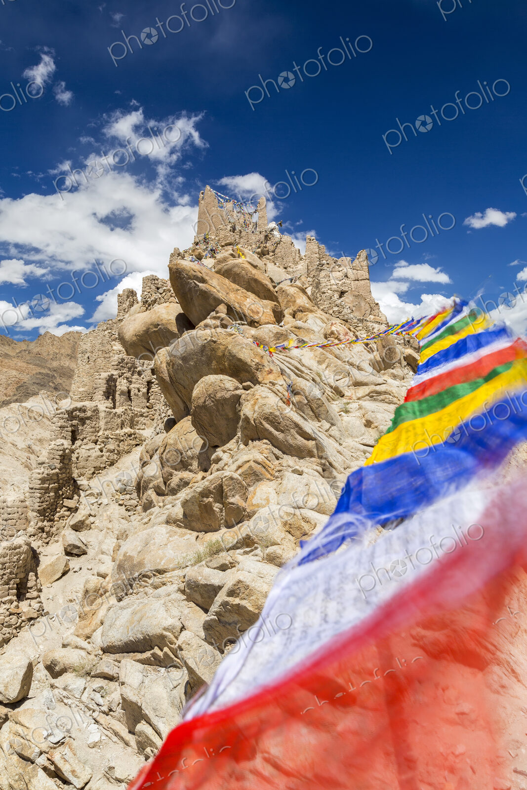 Low angle view of rock-face with colourful prayer flags.