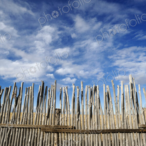 Low angle view of rustic corral fence under blue sky Low angle view of rustic corral fence under blue sky