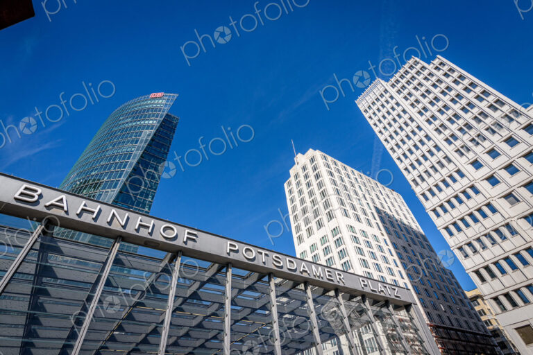 Low angle view of skyscrapers and entrance to Potsdamer Platz railway station, Berlin.