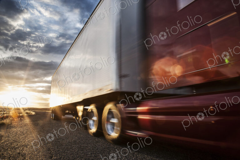 Low angle view of the cab and trailer on a Class 8 commercial truck on the highway at…