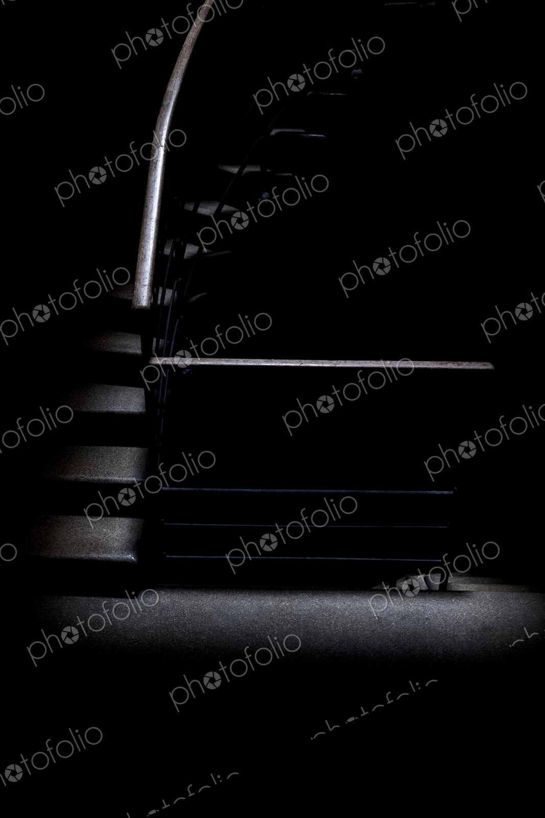 Low key detail of room with a stairway with metal handrail.