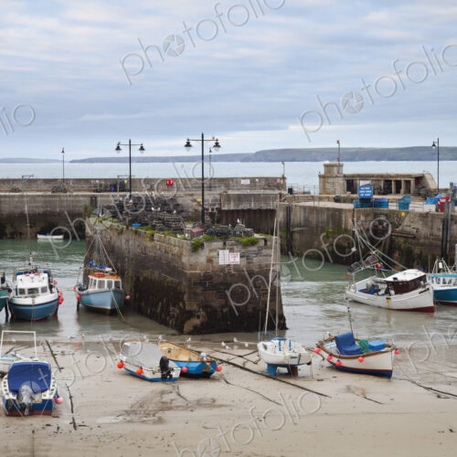 Low tide at a Cornish harbour, sea coast fishing village, boats moored, beached on the… Low tide at a Cornish harbour, sea coast fishing village, boats moored, beached on the…