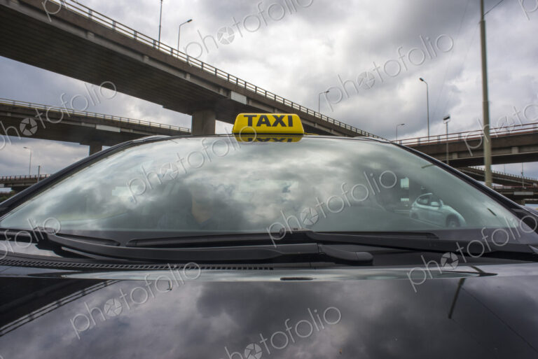 Luxurious car with a taxi sign on its roof.