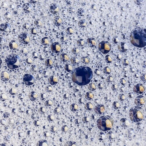 Macro view of tightly packed soap bubbles showing detailed surface tension and tiny…