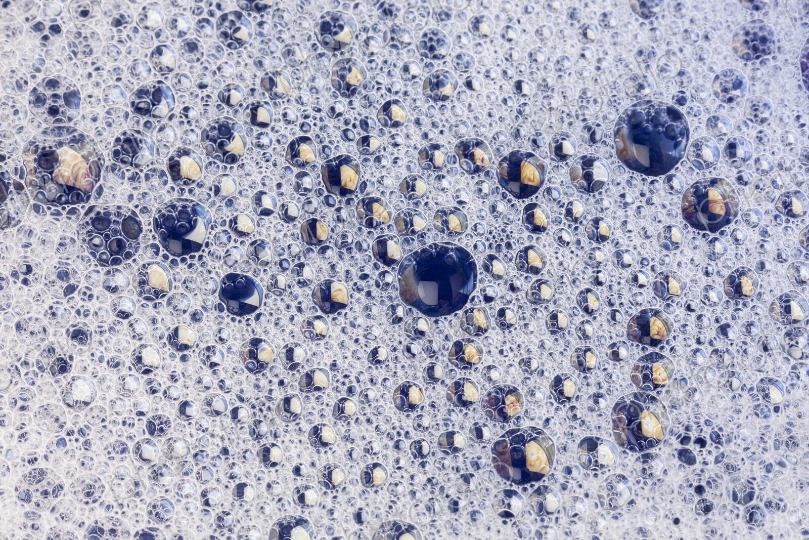 Macro view of tightly packed soap bubbles showing detailed surface tension and tiny…