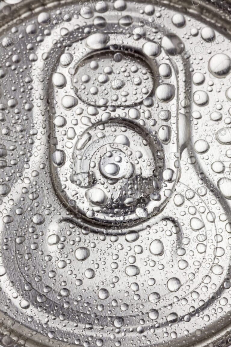 Macro view of water droplets covering the top of a sealed aluminum beverage can. Cold,…