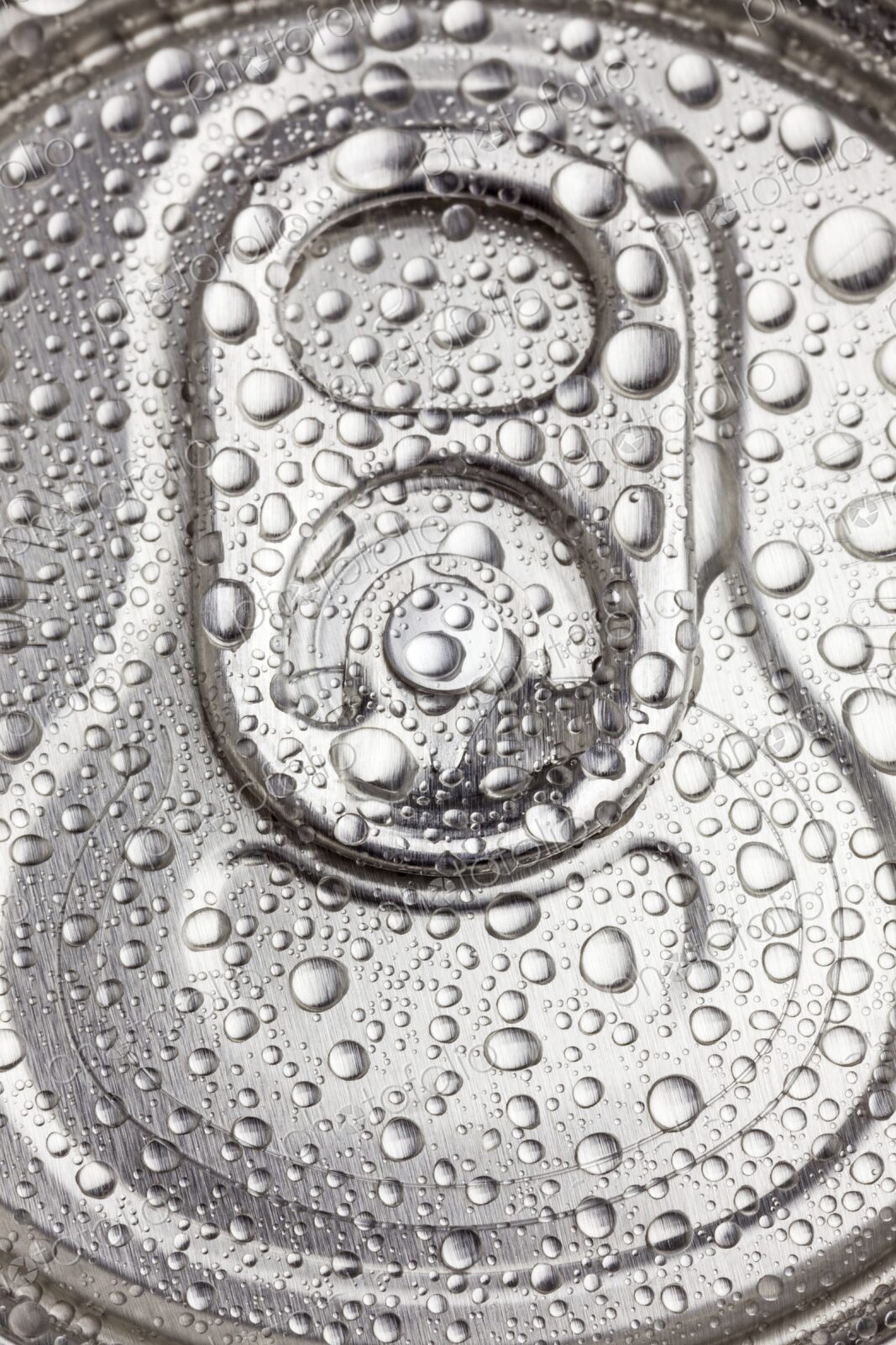 Macro view of water droplets covering the top of a sealed aluminum beverage can. Cold,…