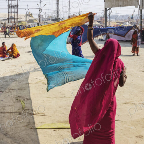 Maha Shivratri Hindu festival, a woman in a red sari and headscarf, waving blue and…