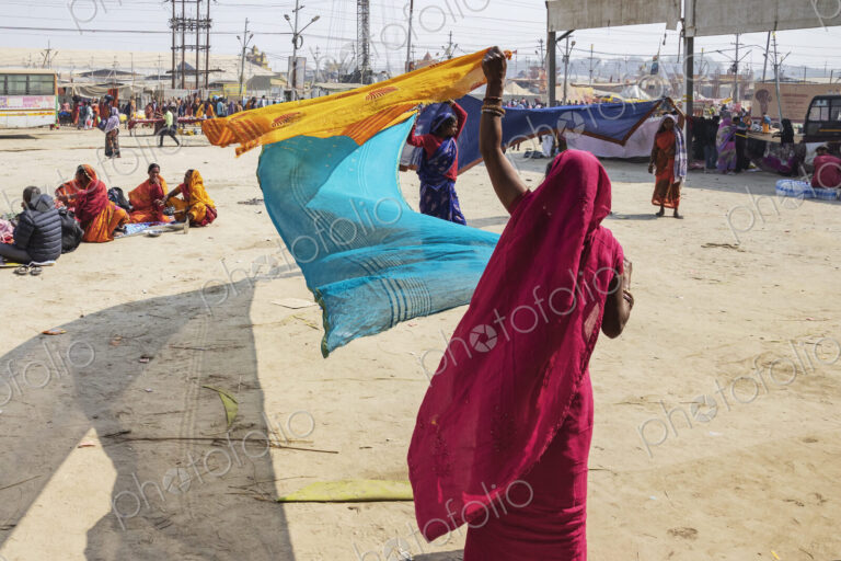 Maha Shivratri Hindu festival, a woman in a red sari and headscarf, waving blue and…
