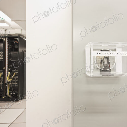 Mains power switch in computer server room with computer server cabinet.