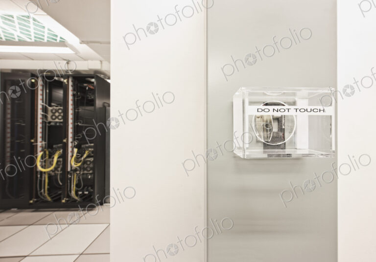 Mains power switch in computer server room with computer server cabinet.