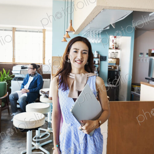 Male Japanese professional standing in a co-working space, smiling at camera. Male Japanese professional standing in a co-working space, smiling at camera.