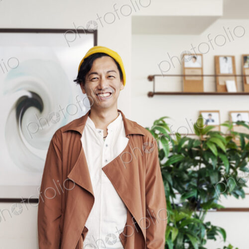 Male Japanese professional standing in a co-working space, smiling at camera. Male Japanese professional standing in a co-working space, smiling at camera.