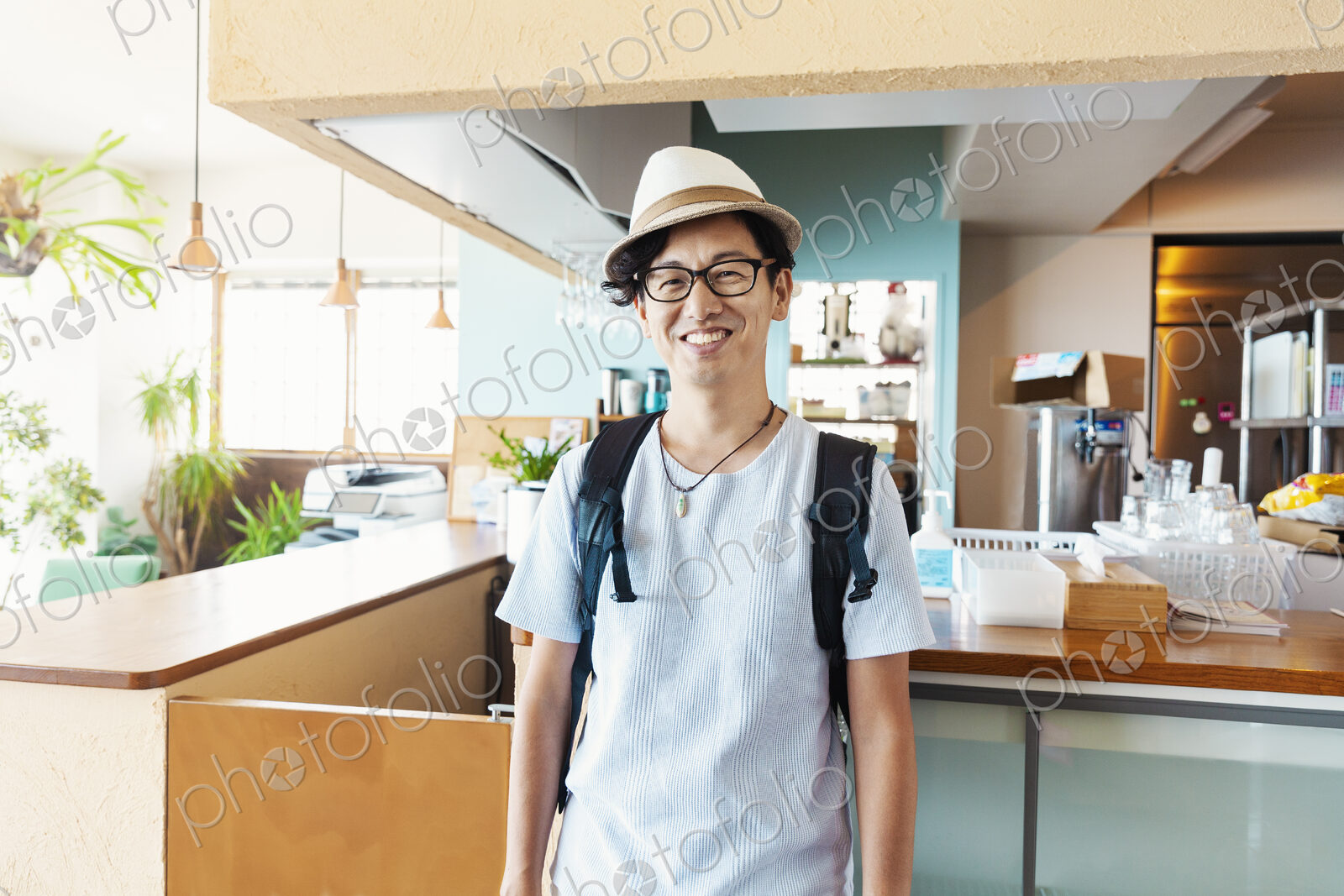 Male Japanese professional standing in a co-working space, smiling at camera.