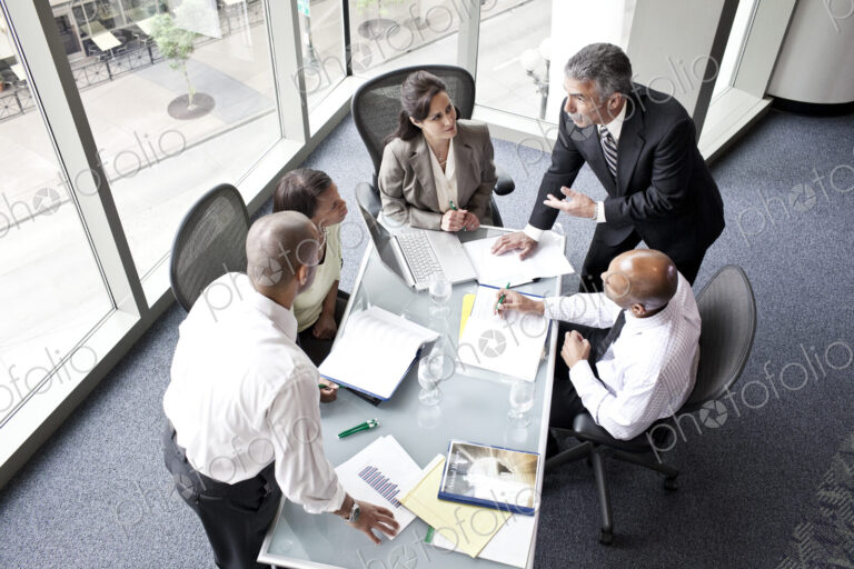 Male and female business people in a meeting at a conference table, overhead view