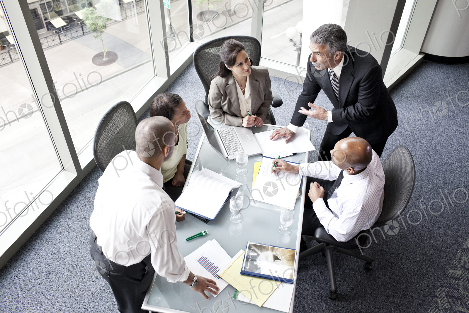 Male and female business people in a meeting at a conference table, overhead view