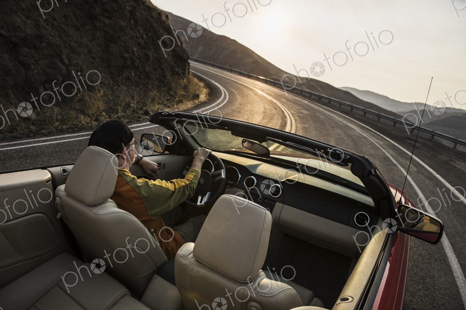 Male driver in a convertible sports car driving on the highway