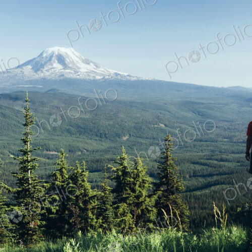 Male hiker on a mountain summit, looking at the landscape towards Mount Hood Male hiker on a mountain summit, looking at the landscape towards Mount Hood
