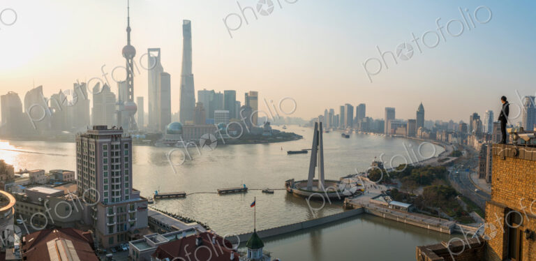 Man admiring view over Huangpu River & Shanghai skyline in early morning, Shanghai, China
