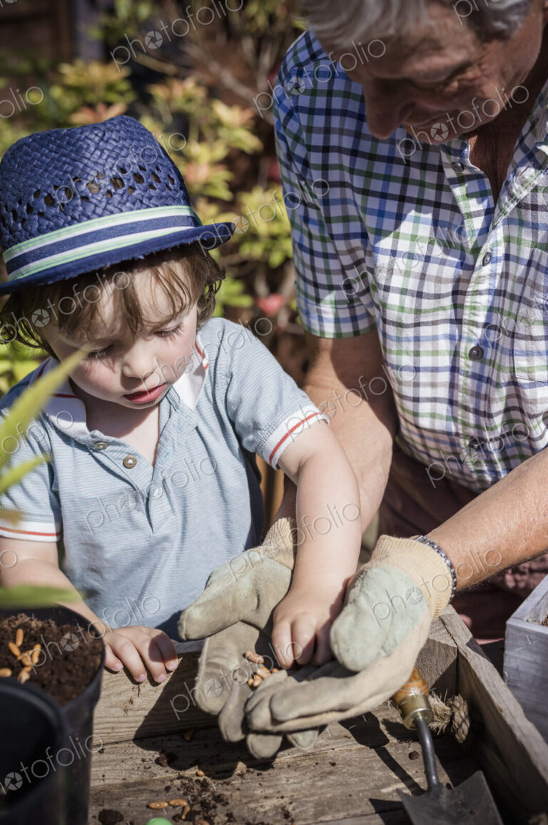 Man and a young child gardening, planting seeds.